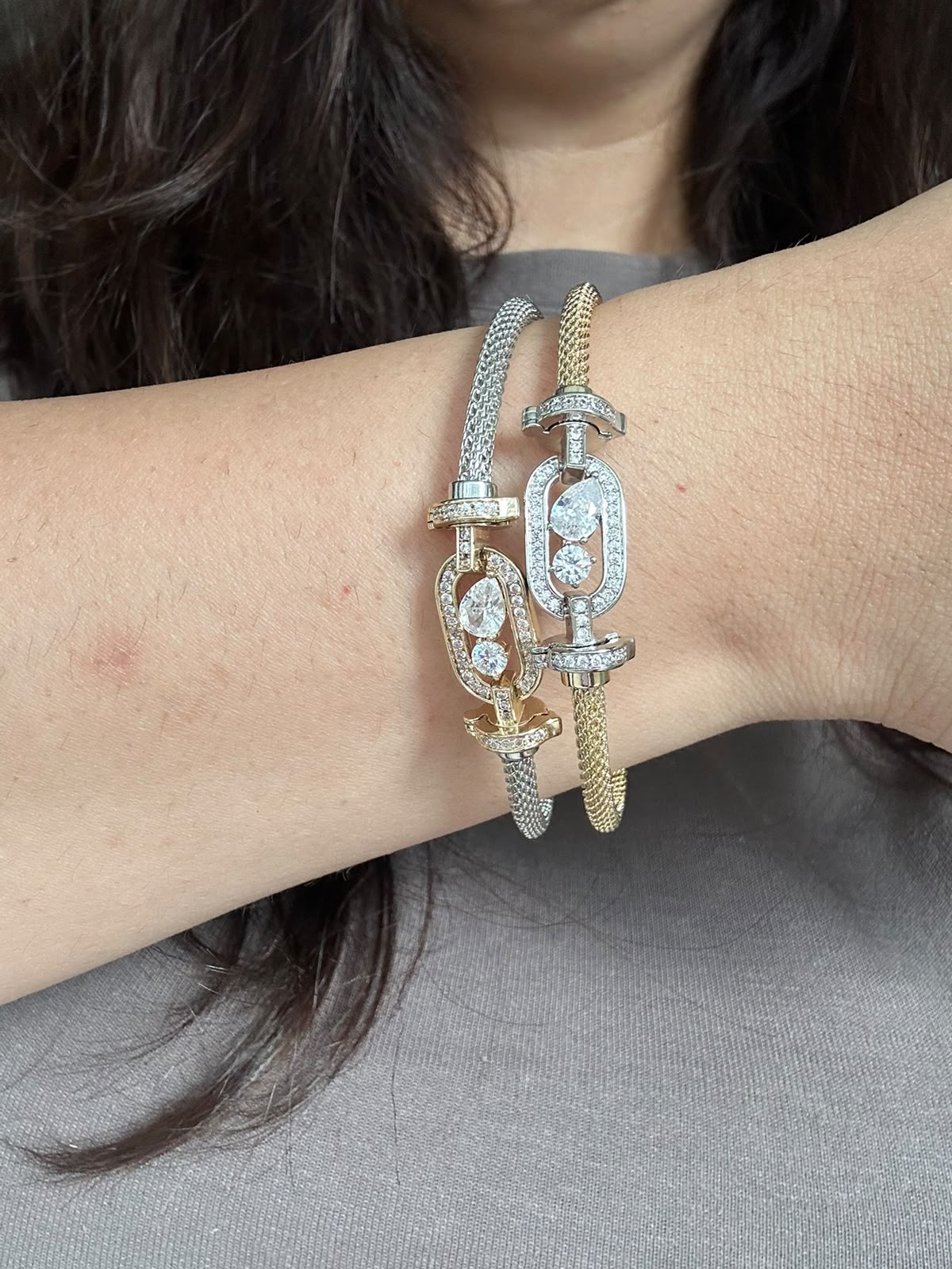 Two Kinahh bracelets worn together, showing their stone details