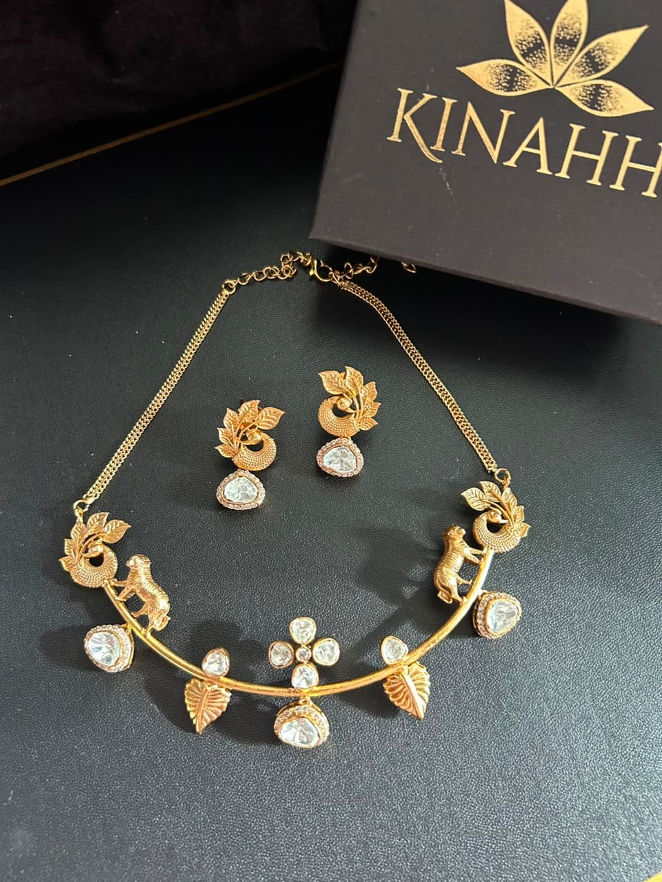 Kinahh necklace and matching earrings beside the branded jewellery box