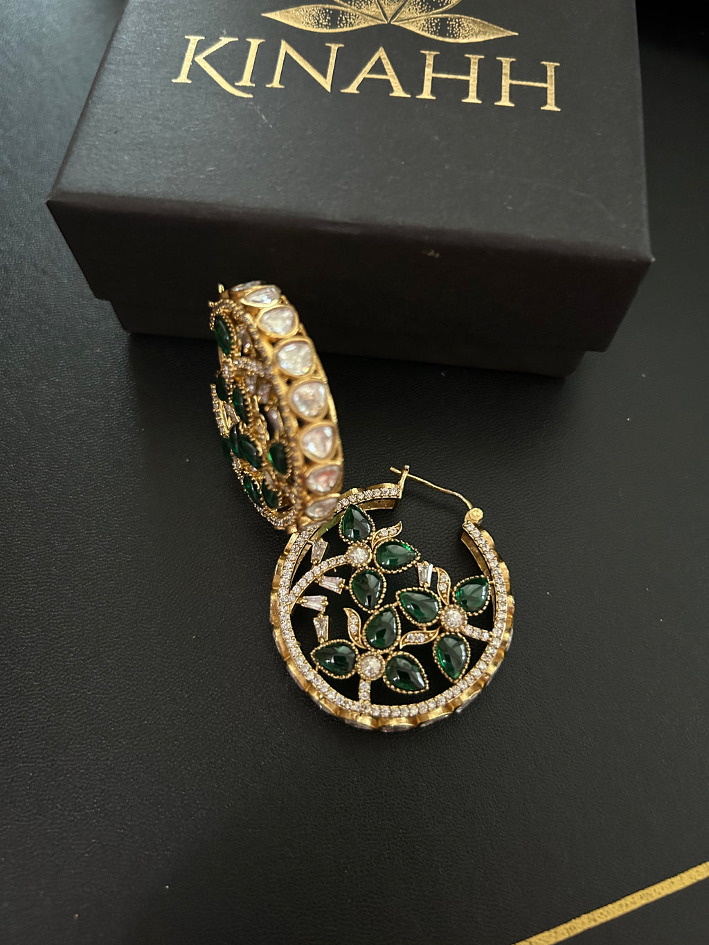 Alternate view of Chaand brass hoop earrings showing green stone floral motifs, moissanite polki borders and slim closures.