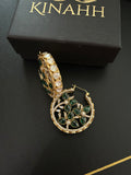 Chaand circular brass hoop earrings with green teardrop stones and moissanite polki, photographed beside a KINAHH box.