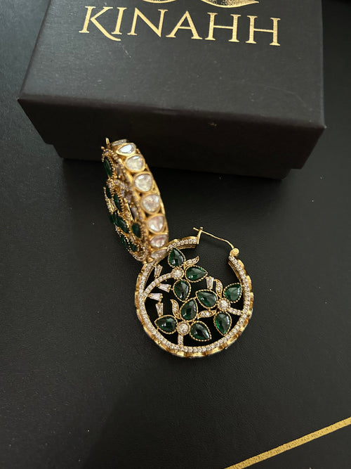 Chaand circular brass hoop earrings with green teardrop stones and moissanite polki, photographed beside a KINAHH box.
