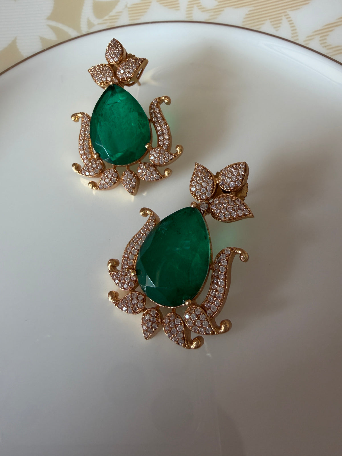Gul Earrings close-up with green stone drops and polished brass setting.