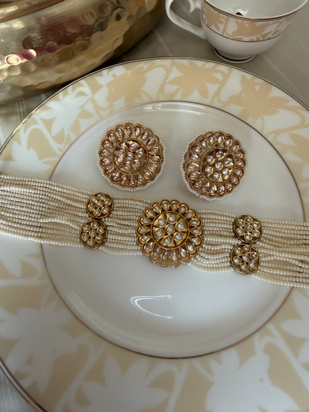 Renuka ivory pearl choker necklace set with gold-tone clear-stone motifs and matching stud earrings