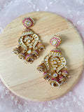 Noor chandelier earrings with pink enamel, clear polki stones and pearl-like drops, shown as a pair on a wooden display.