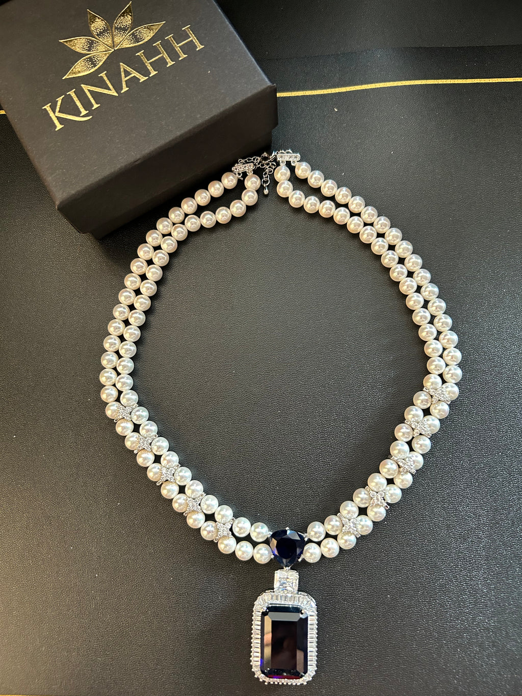 Rhea Necklace by KINAHH with shell pearls and a blue stone pendant.