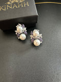 Sephora earrings with white pearl-like accents and purple and clear stone floral details, photographed beside a black KINAHH box.