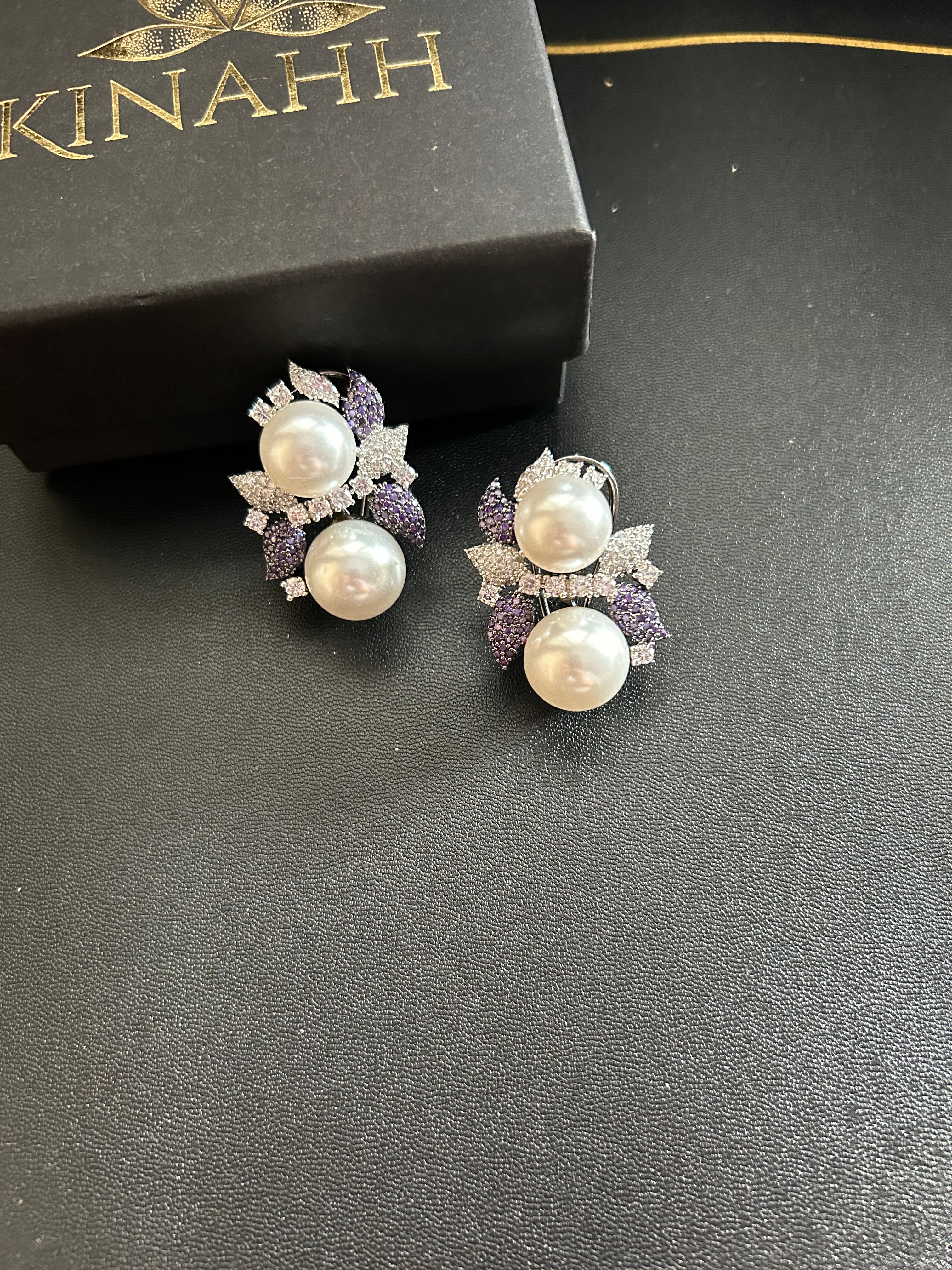 Sephora earrings with white pearl-like accents and purple and clear stone floral details, photographed beside a black KINAHH box.