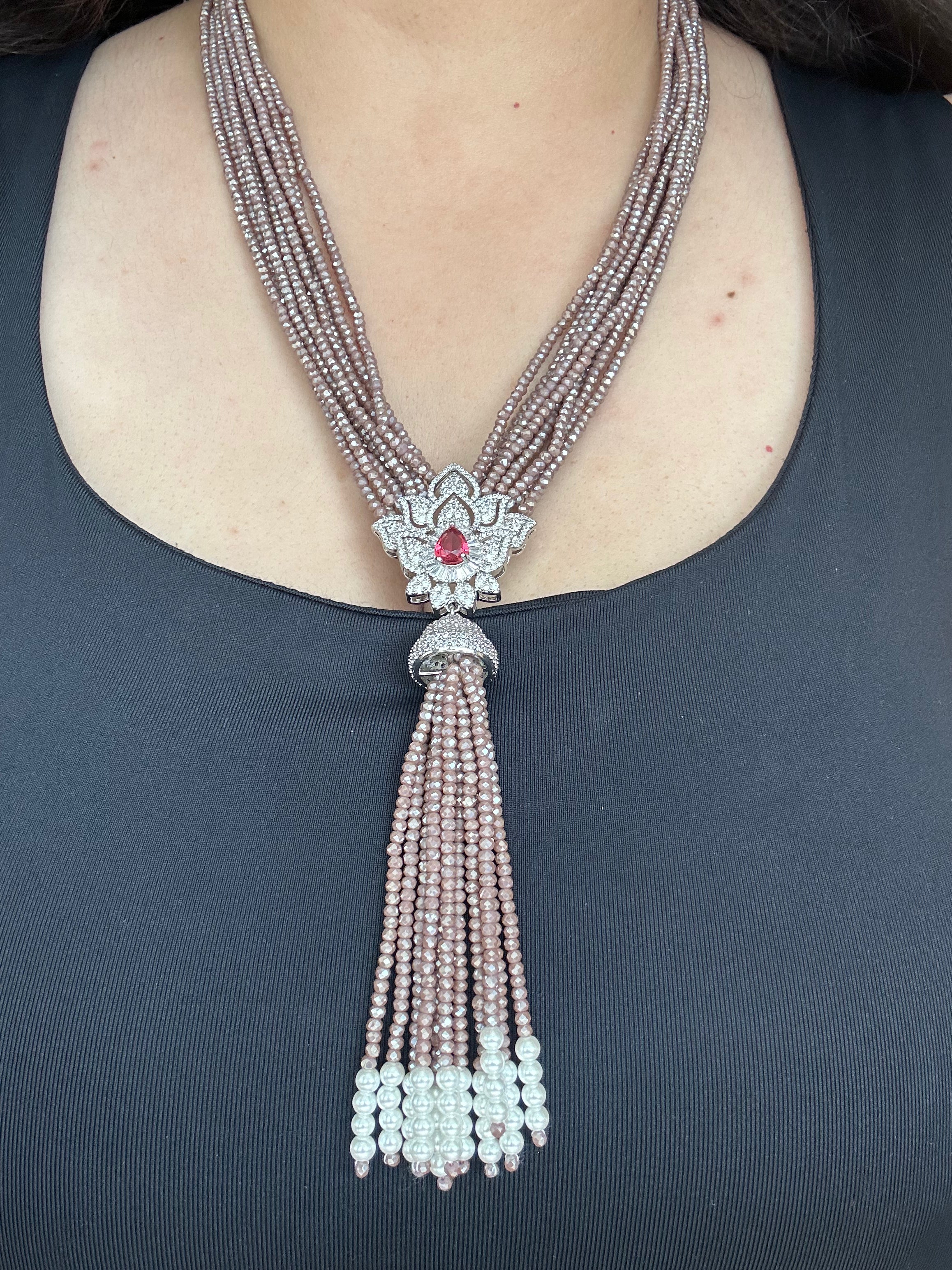 Worn view of Adaa Necklace showing the multi-strand beads, floral pendant and tassel.