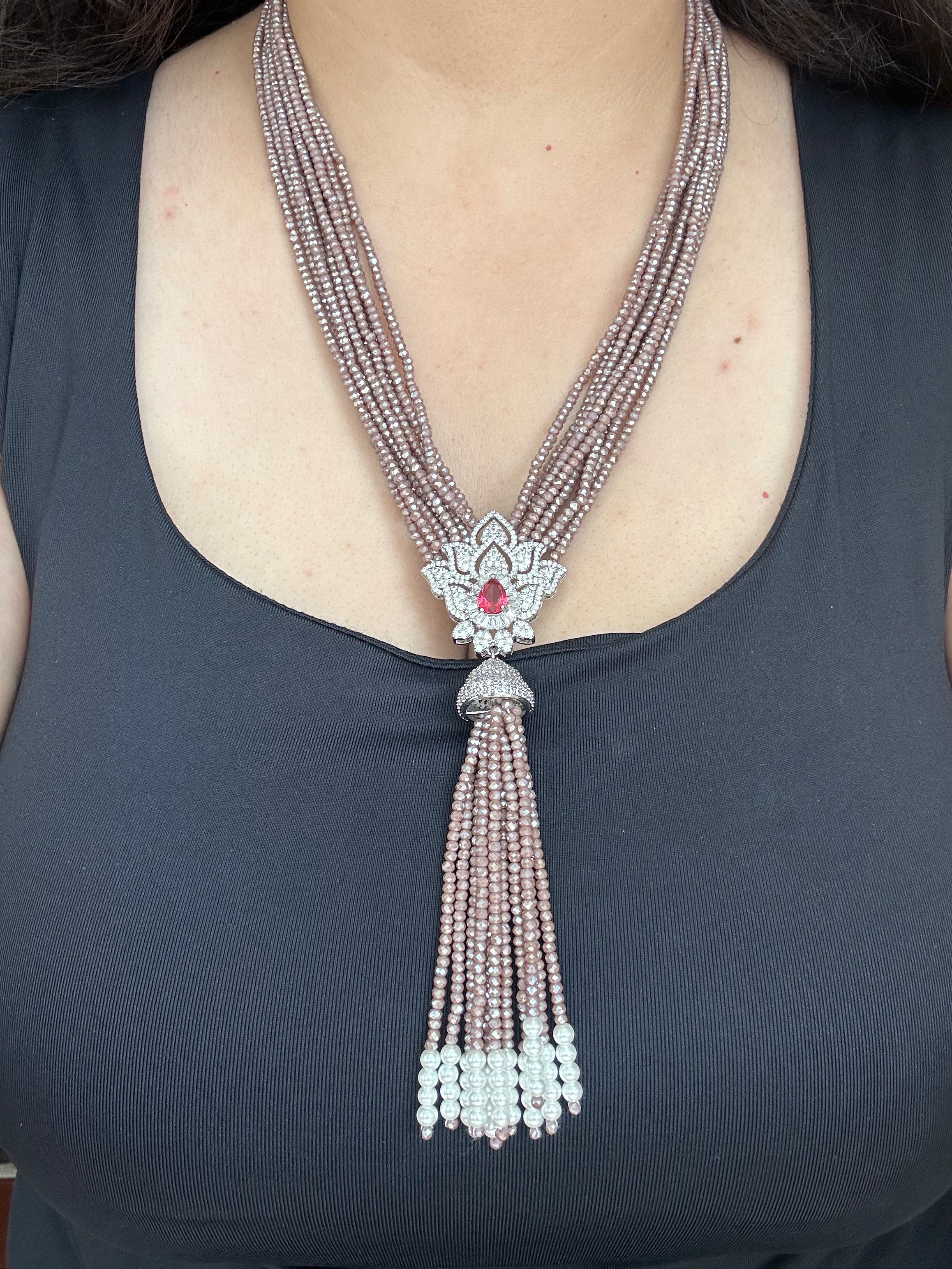 Adaa Necklace by KINAHH worn from the front, showing its full multi-strand design, red-centred floral pendant and long tassel.