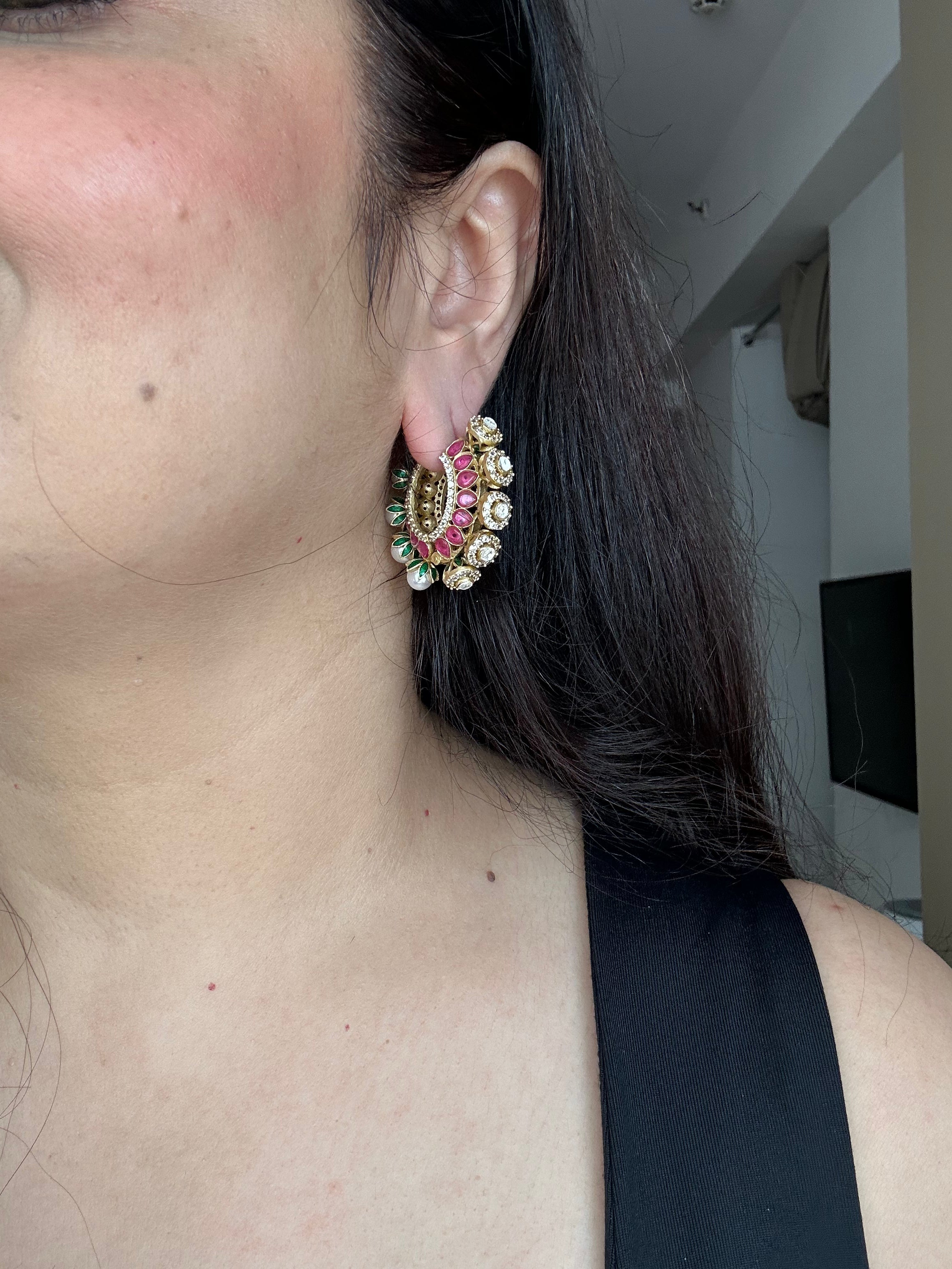 Gulnaar Hoops worn on the ear, showing the gold-tone circular design, pink enamel, clear stones and pearl-like drops.