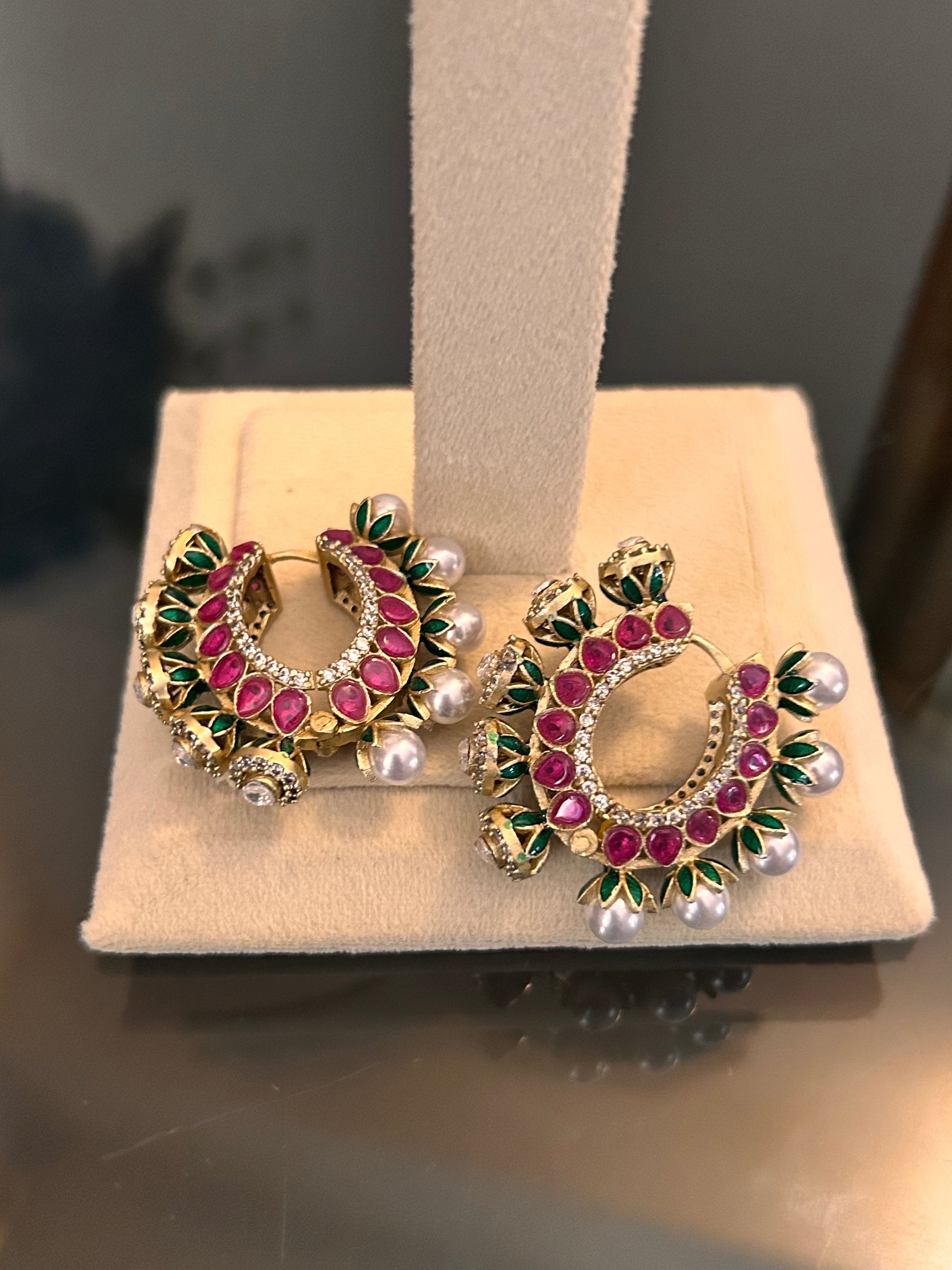Angled pair view of Gulnaar enamel hoops with clear stones and pearl-like drops.