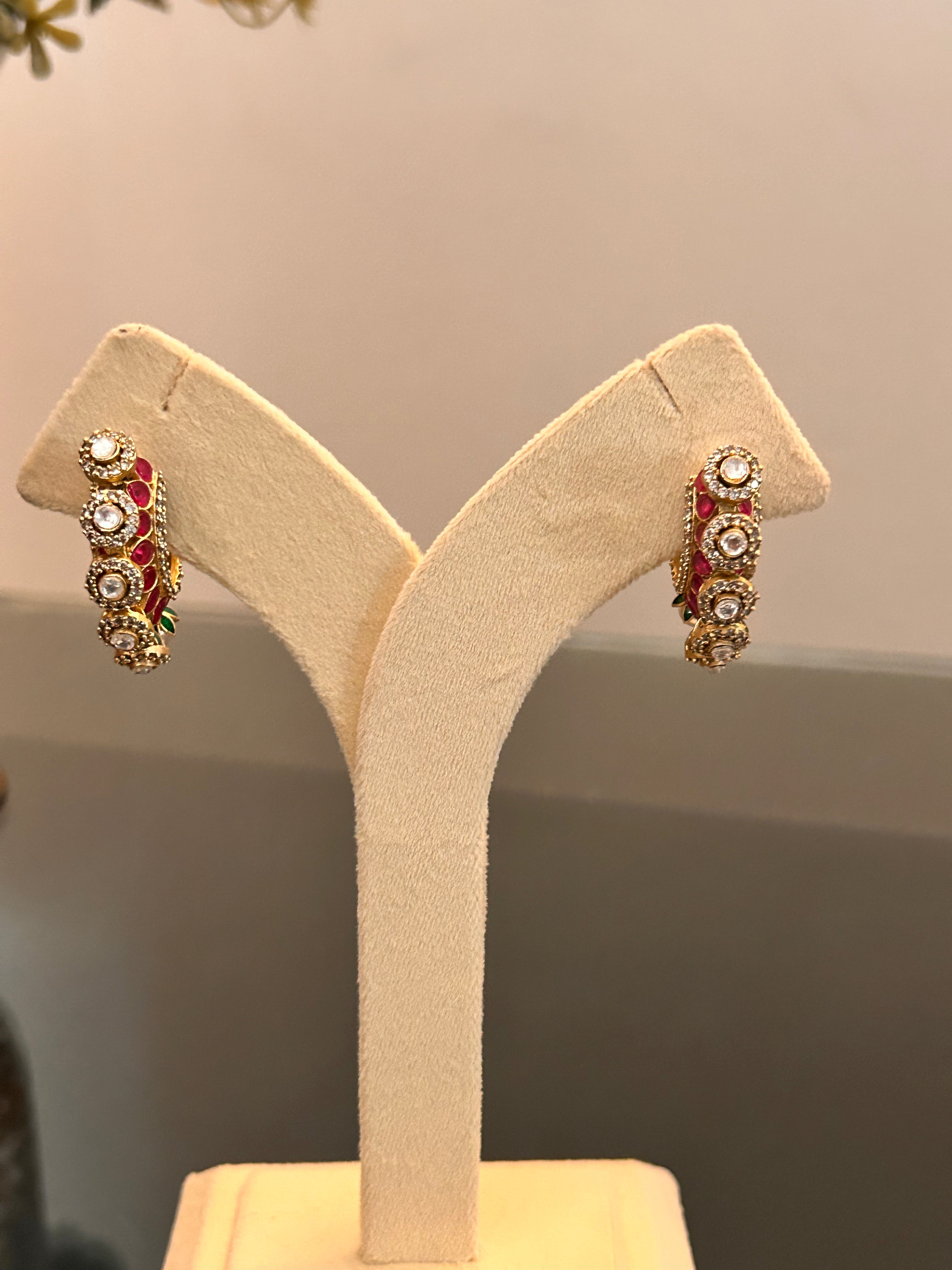 Front view of the clear-stone sides of Gulnaar Hoops hanging from a cream stand.