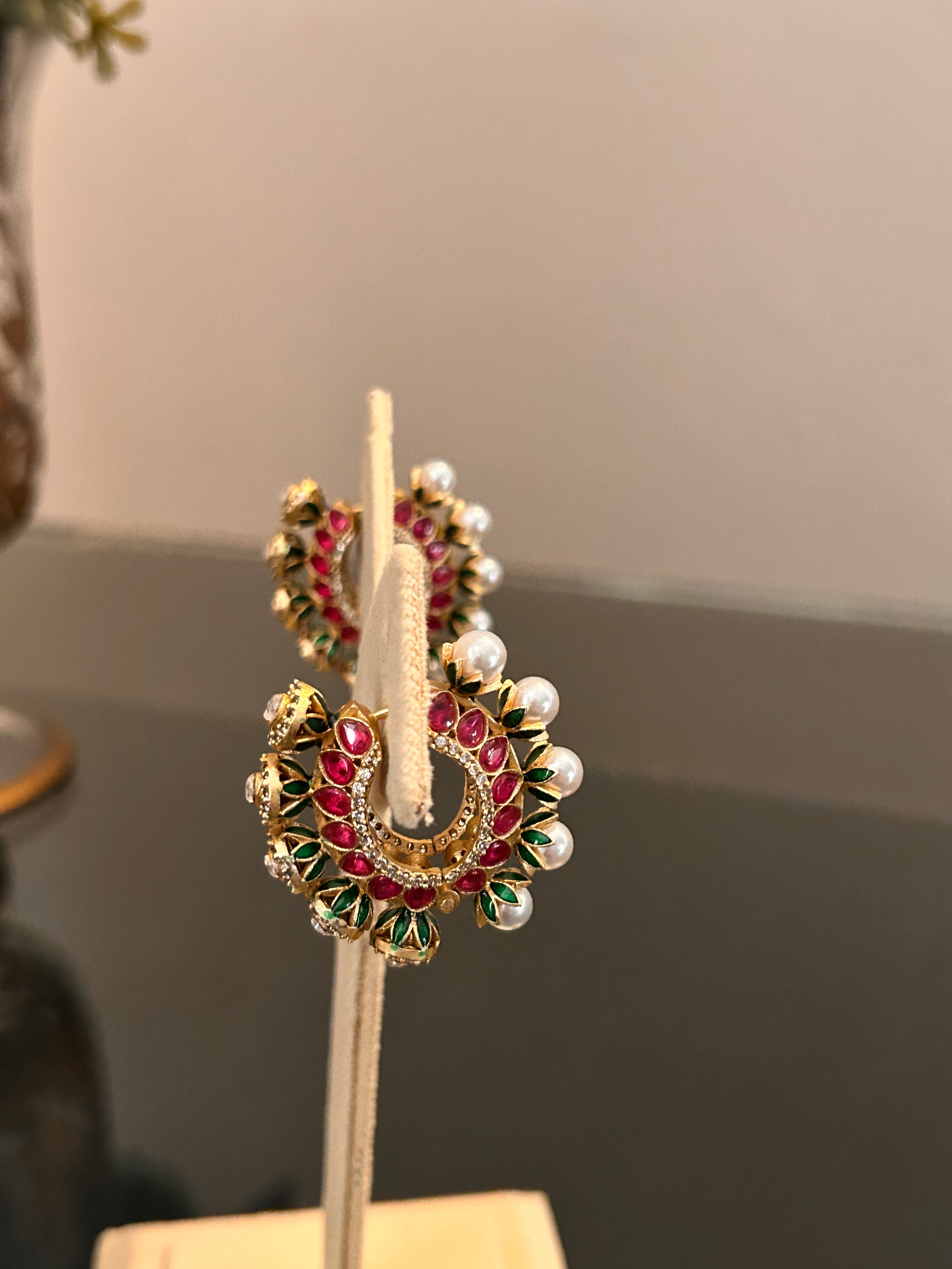 Side view of Gulnaar Hoops on a cream stand, showing the circular enamel design.