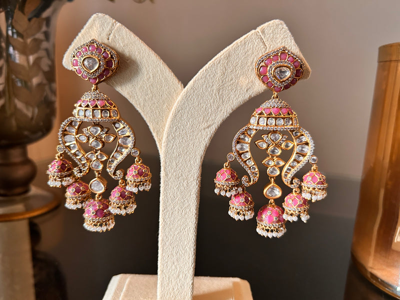 Noor Earrings by KINAHH, pink enamel and clear polki-style stones with pearl-like drops, shown as a pair on a cream stand.