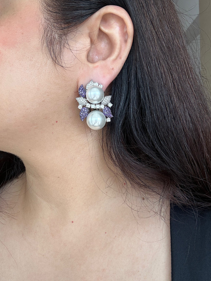 Sephora Earrings by KINAHH worn in profile, showing white pearl-like beads with purple and clear-stone detailing.